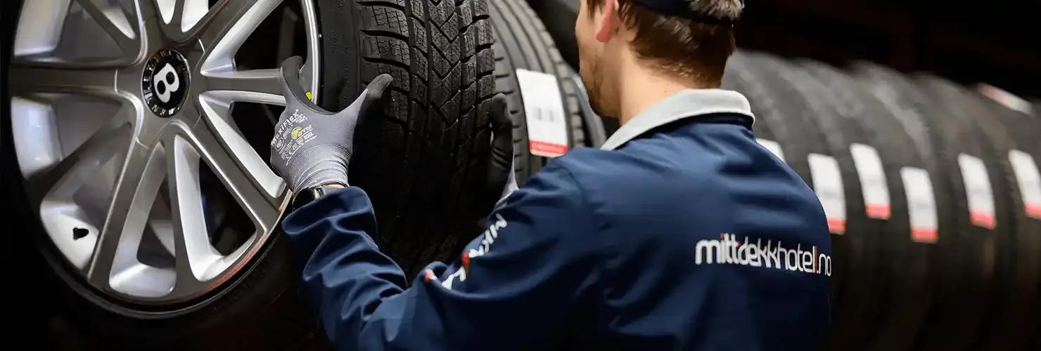 Mitt Dekkhotell — staff handling a wheel in the tire hotel